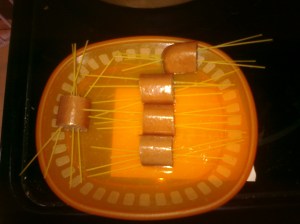 Thread spaghetti through cut up hot dogs